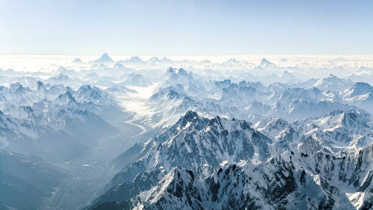 Aerial view across the Himalaya, a glacier running between snow peaks
