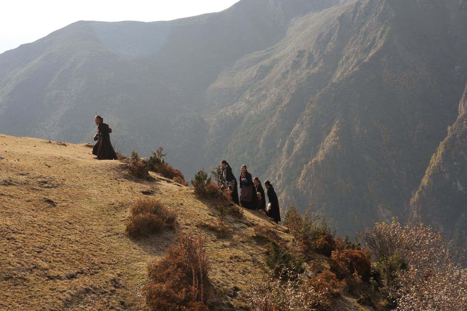 Villagers walking a hillside path above Laya, in the Bhutanese Himalaya