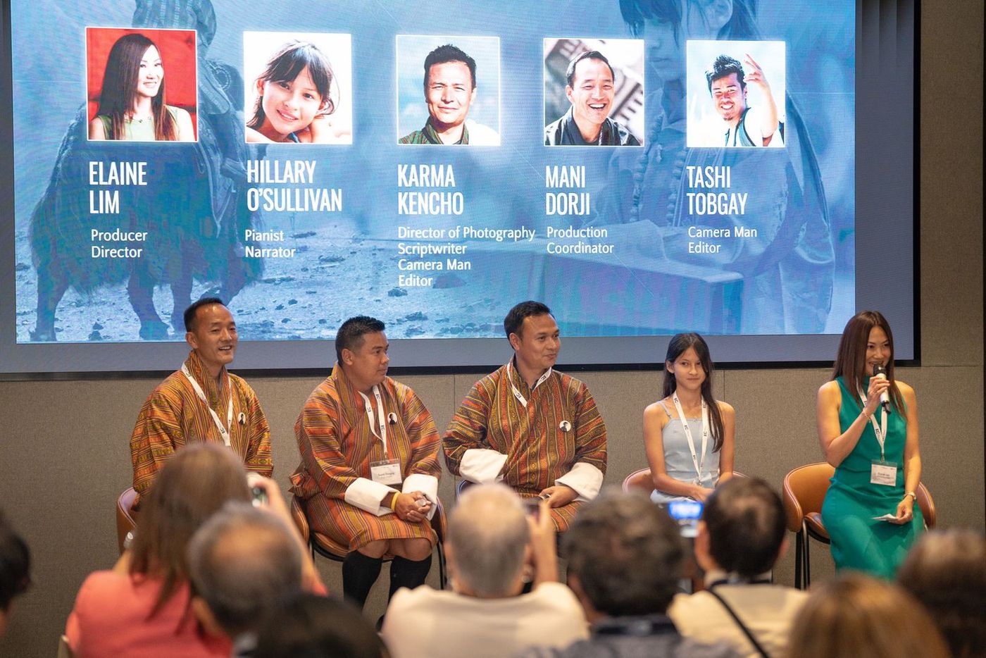 The panel on stage at the Singapore premiere, in front of a slide listing the film’s credits